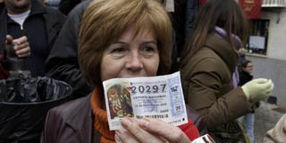Una afortunada muestra su d�cimo premiado en la loter�a de Navidad.